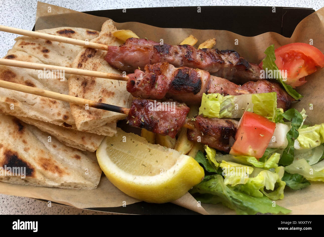 Greek dinner of Souvlaki skewers, with pita bread and salad Stock Photo