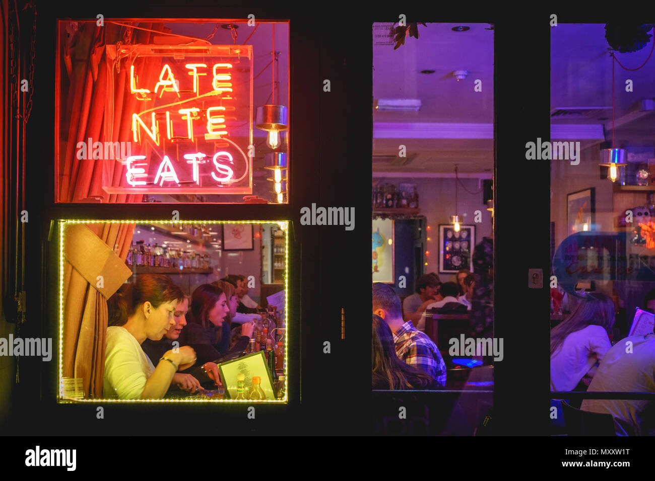 London, UK - October 2017. People drinking cocktails in a club in Soho. Landscape format. Stock Photo