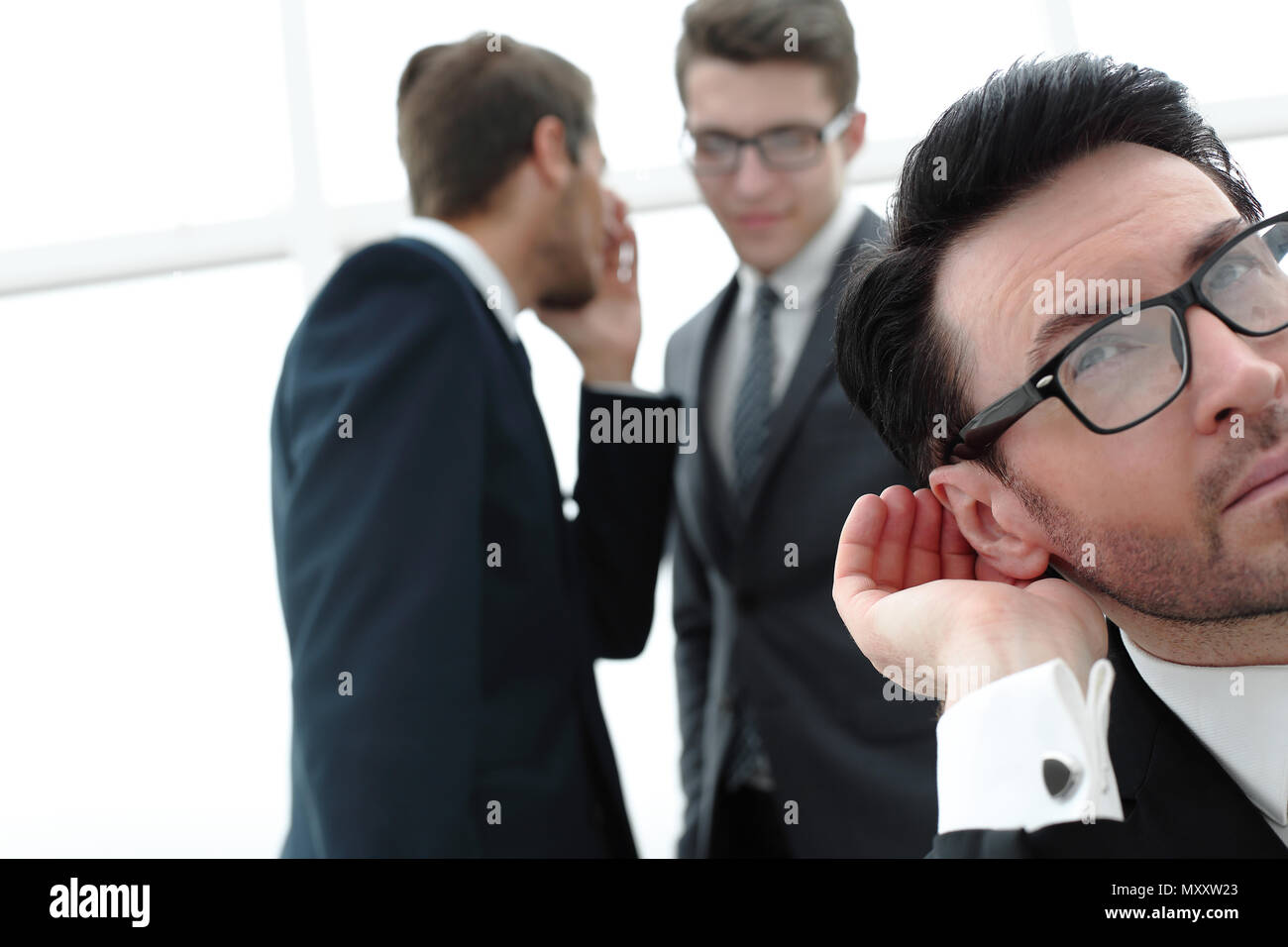 close up.businessman eavesdropping on conversation between colleagues Stock Photo