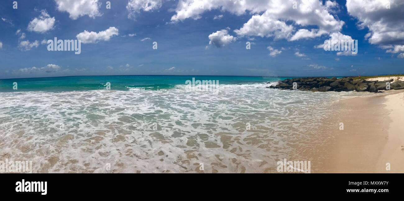 Panorama of a beautiful day at Bayshore / Pebbles Beach (Carlisle Bay) near Bridgetown Barbados (Caribbean Island) - white sand, waves and blue sky Stock Photo