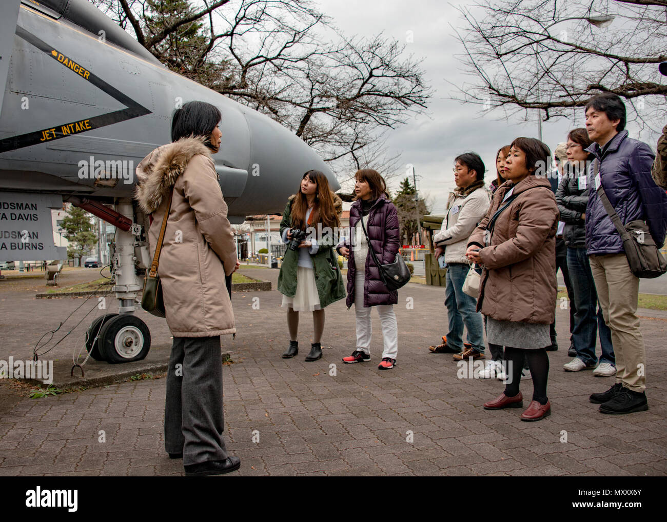161213-N-YD204-017 NAVAL AIR FACILITY ATSUGI, Japan (Dec. 13, 2016) Naval Air Facility (NAF) Atsugi Host Nation Relation’s Office (HNRO) Representative Sumie Maruyama leads a group of visitors through the base’s Alliance Park during a “Twitter Tour” of the installation. NAF Atsugi HNRO held the tour as part of a community outreach initiative to allow followers of the command’s social media an opportunity to learn more about the base. (U.S. Navy photo by Petty Officer 3rd Class Matthew C. Duncker/Released) Stock Photo