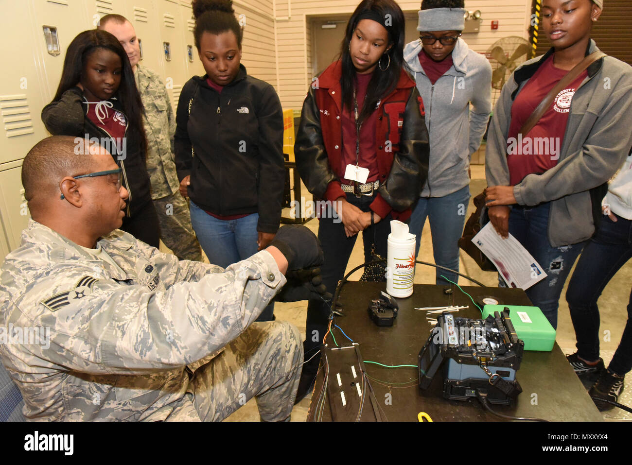 U.S. Air Force Senior Airman Antonio Qualls, a cable and antenna installation specialist with the 202d Engineering Installation Squadron (EIS), 116th Air Control Wing (ACW), Georgia Air National Guard, explains how to splice wire to a JROTC students, Robins Air Force Base, Ga., Dec. 2, 2016.  Airmen from the 202d EIS and 116th ACW spoke to JROTC students from Warner Robins and Callaway High Schools about the 202d EIS and 116th ACW career opportunities and about domestic operations and federal missions. (U.S. Air National Guard photo by Master Sgt. Regina Young) Stock Photo