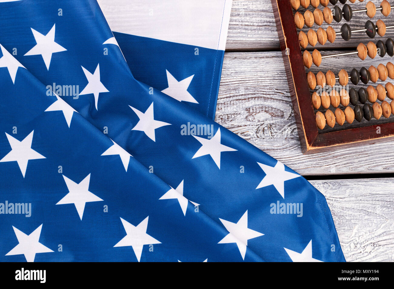 American flag and old account machine. National flag of USA and vintage wooden abacus on wooden background. Stock Photo