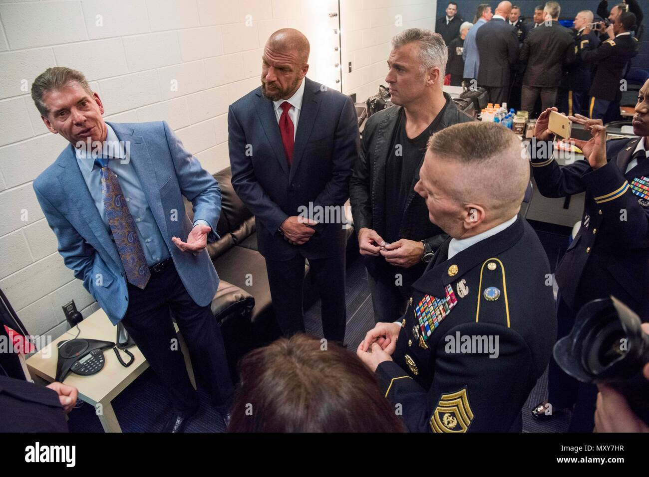 WWE CEO Vince McMahon, Paul 'Triple H' Levesque, and Shane McMahon speak to Army Command Sgt. Maj. John W. Troxell, Senior Enlisted Advisor to the Chairman  of the Joint Chiefs of Staff, before the 14th Annual Tribute to the Troops Event at the Verizon Center in Washington, D.C., Dec. 13, 2016. WWE Tribute to the Troops is an annual event held by WWE and Armed Forces Entertainment in December during the holiday season since 2003, to honor and entertain United States Armed Forces members. WWE performers and employees travel to military camps, bases and hospitals, including the Walter Reed Army  Stock Photo