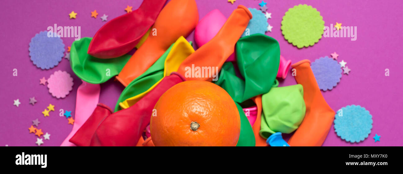 Banner festive poster balloons orange Confetti carnival background ultraviolet. Flat lay top view Stock Photo