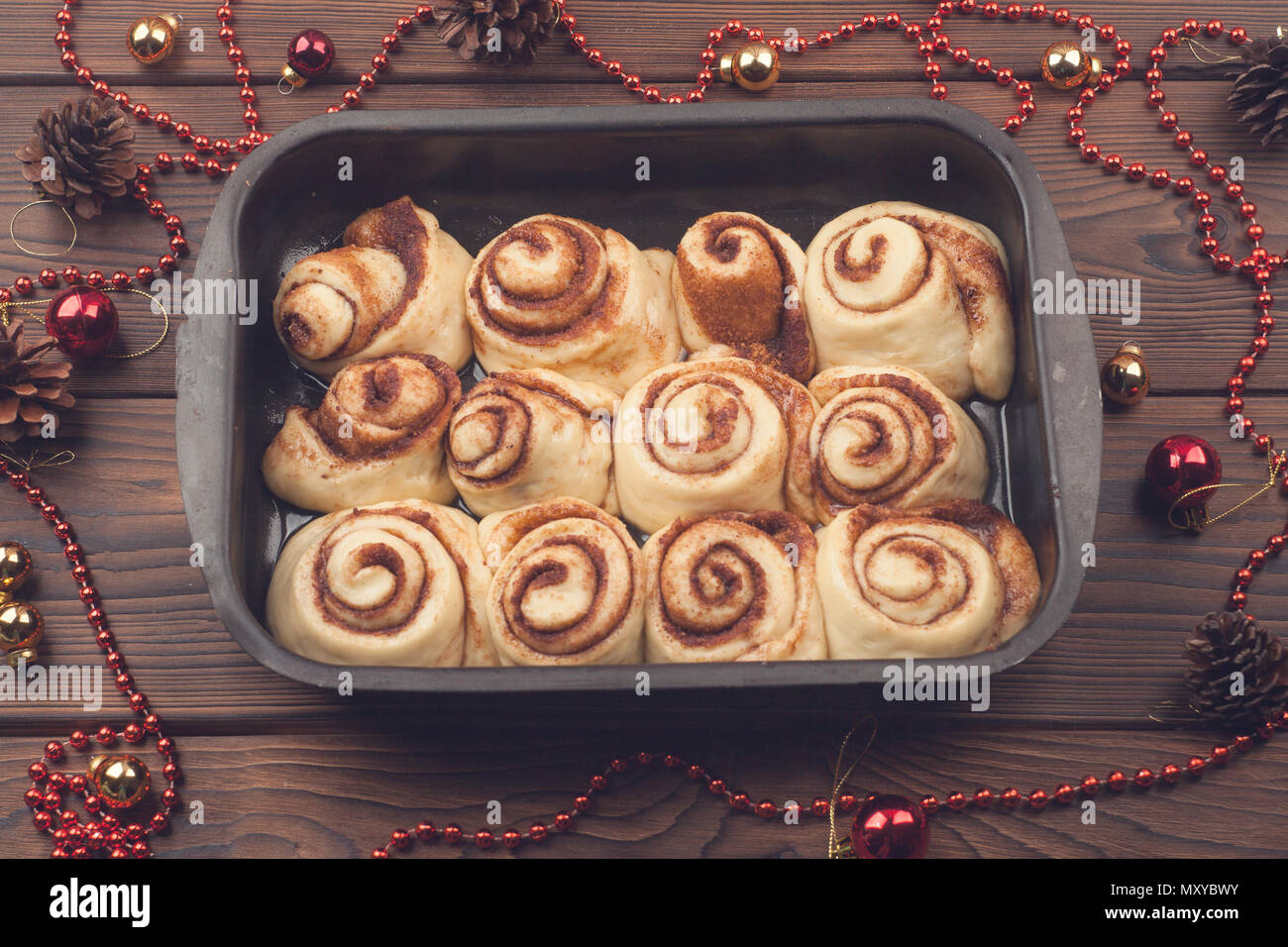 Raw cinnamon rolls. Preparation process - unbaked dough, waiting befor baking, new year atmosphere Stock Photo