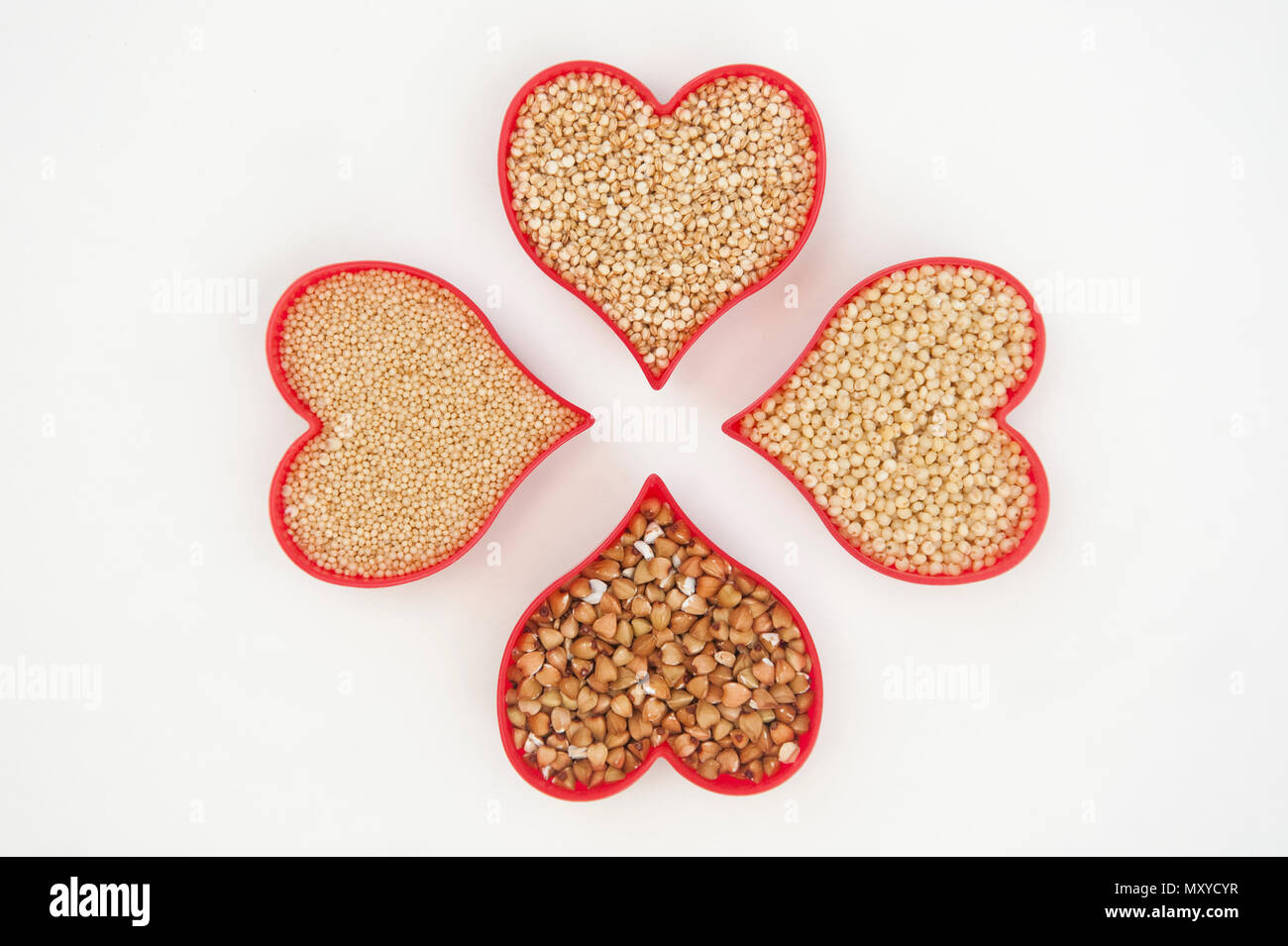 Four hearts filled with super seeds amaranth, millet, buckwheat and quinoa isolated on white Stock Photo