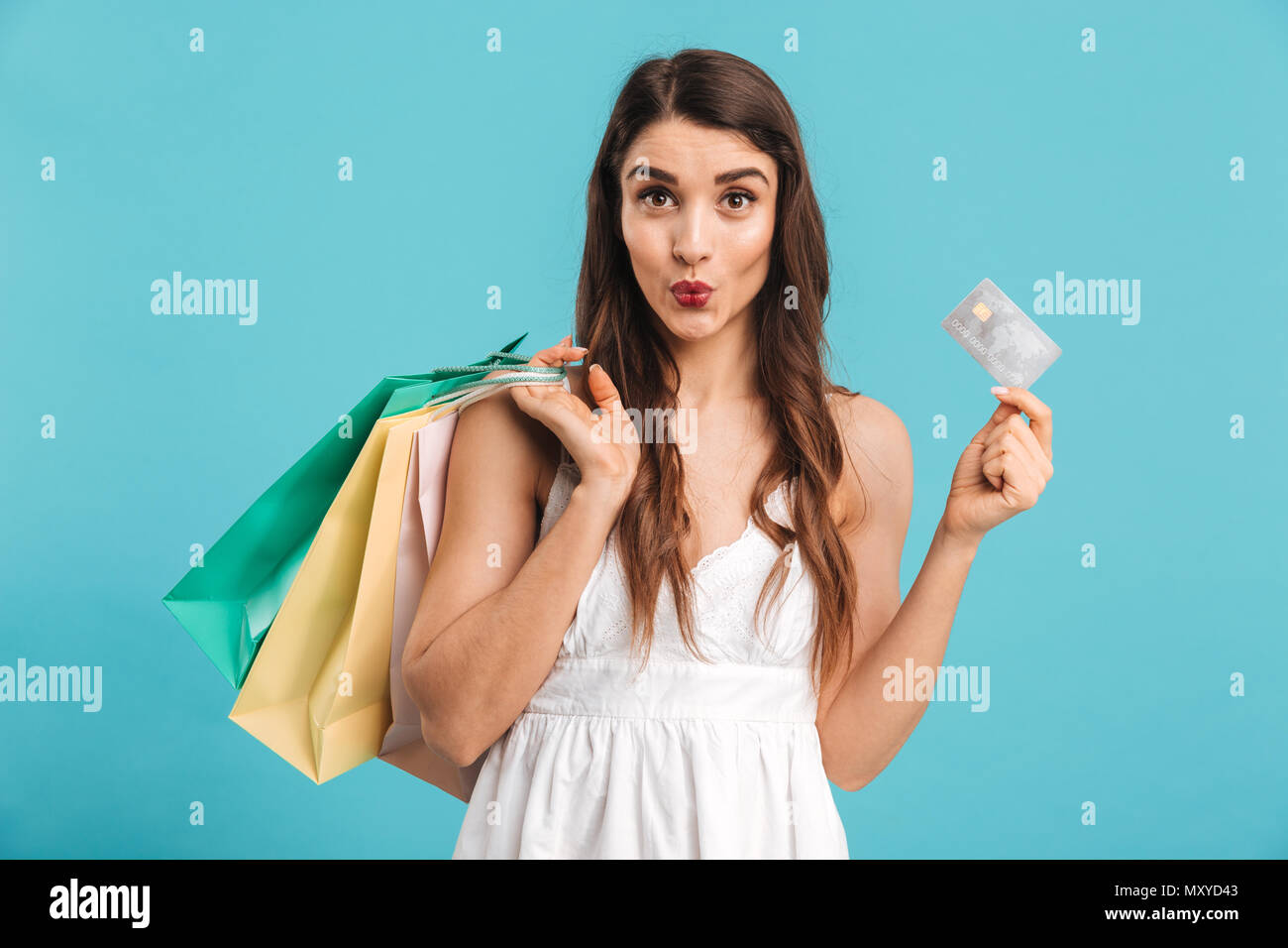 Portrait of a pretty girl in summer dress holding shopping bags and ...