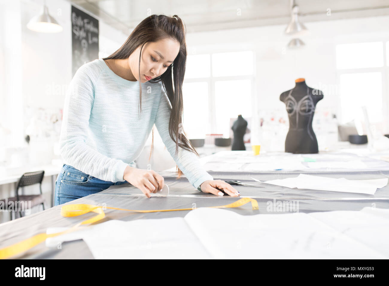 Portrait of Asian female tailor tracing fabric with white chalk while sewing  custom made clothes in modern atelier workshop, copy space Stock Photo -  Alamy