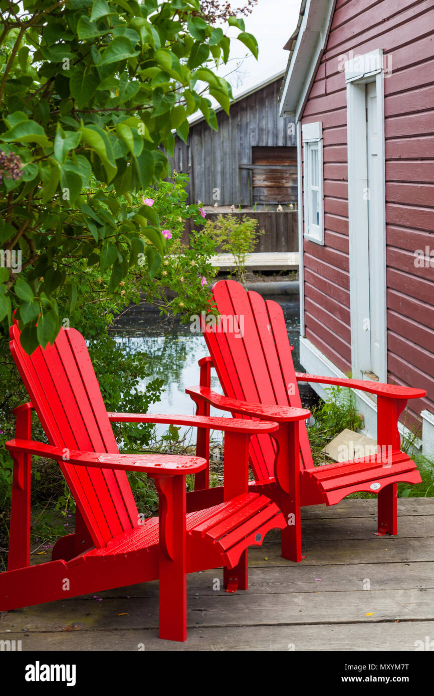 Two Wooden Lawn Chairs On A Wood Plank Deck In Steveston British