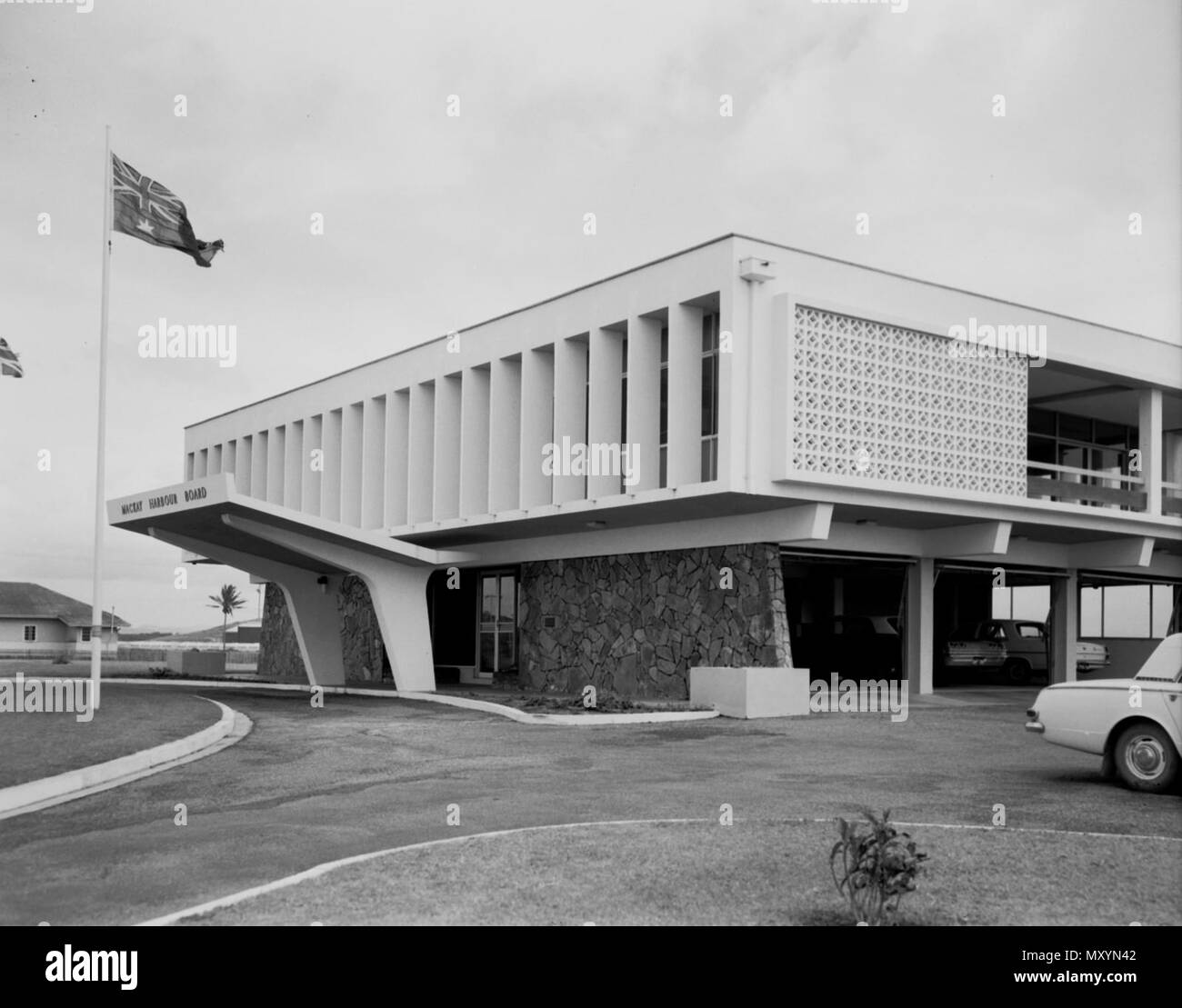 Mackay Harbour Board building, c 1964. The Mackay Harbour Board office building was designed by architect Russell Gibbins. It passed into the ownership of North Queensland Bulk Ports Corporation Limited in 2009. While it met some of the criteria to be listed on the Queensland Heritage Register, due to being surrounded by bulk petrol, diesel and sulphuric acid tanks the building could no longer be used and a decision was taken in 2011 that it would not be heritage listed. Stock Photo