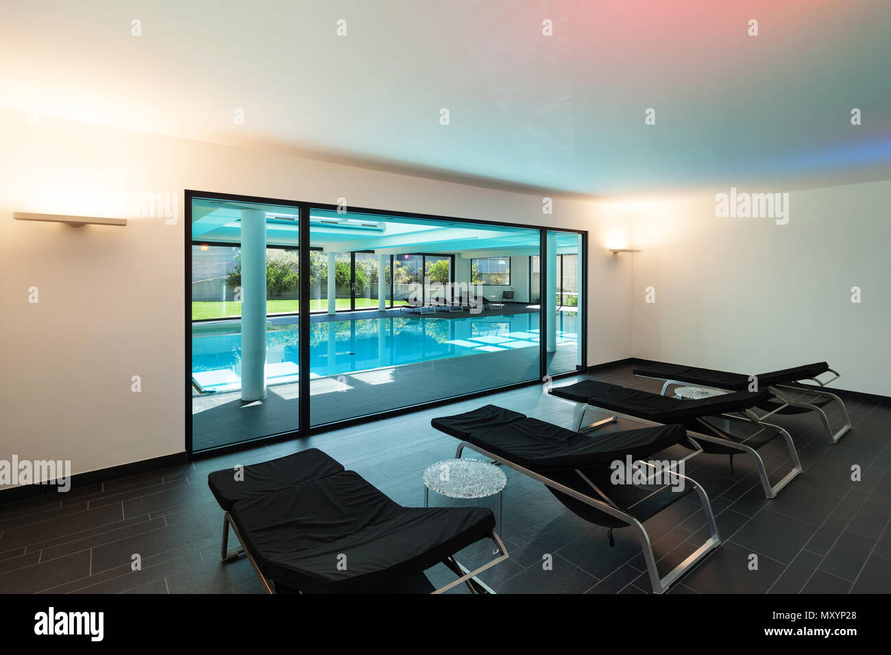 indoor swimming pool of a modern house with spa, room with sunbeds Stock Photo