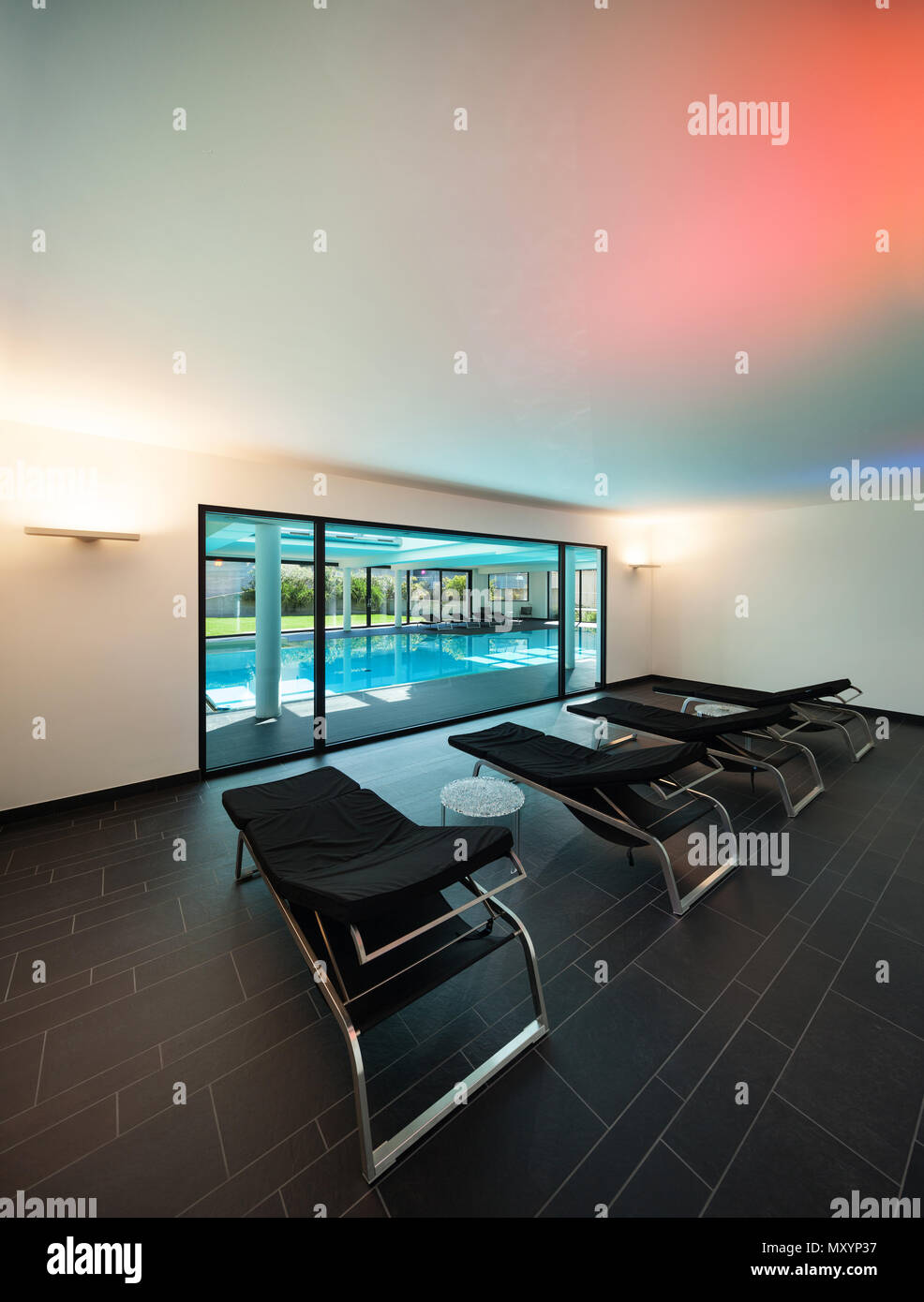 indoor swimming pool of a modern house with spa, room with sunbeds Stock Photo