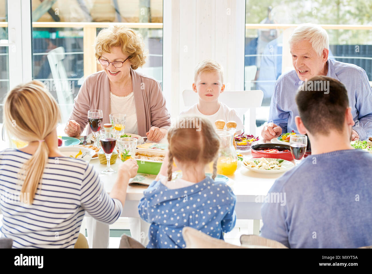 Portrait of happy family enjoying dinner together sitting round festive