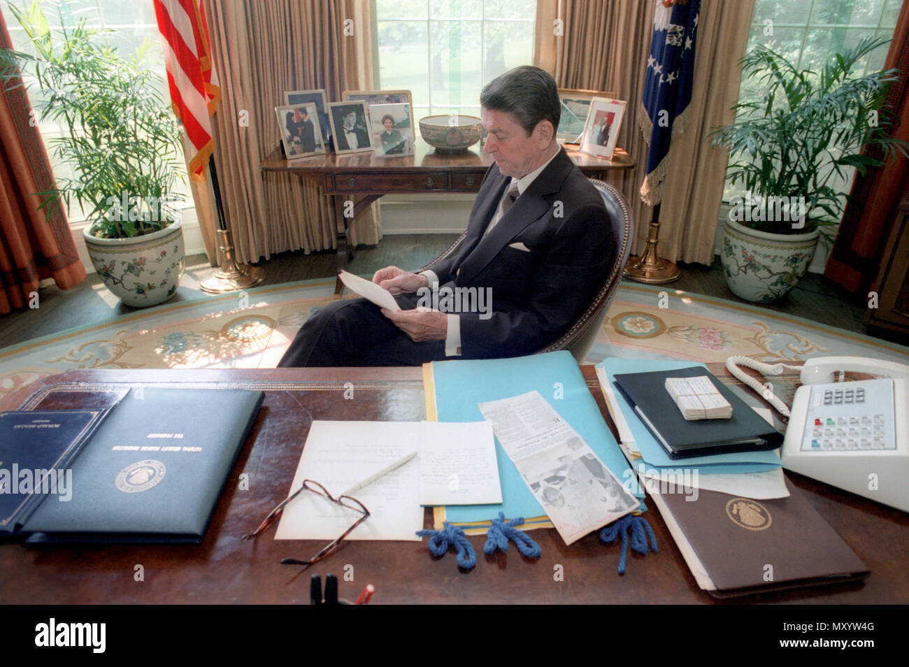 4/28/1981 President Reagan reading in the Oval Office Stock Photo