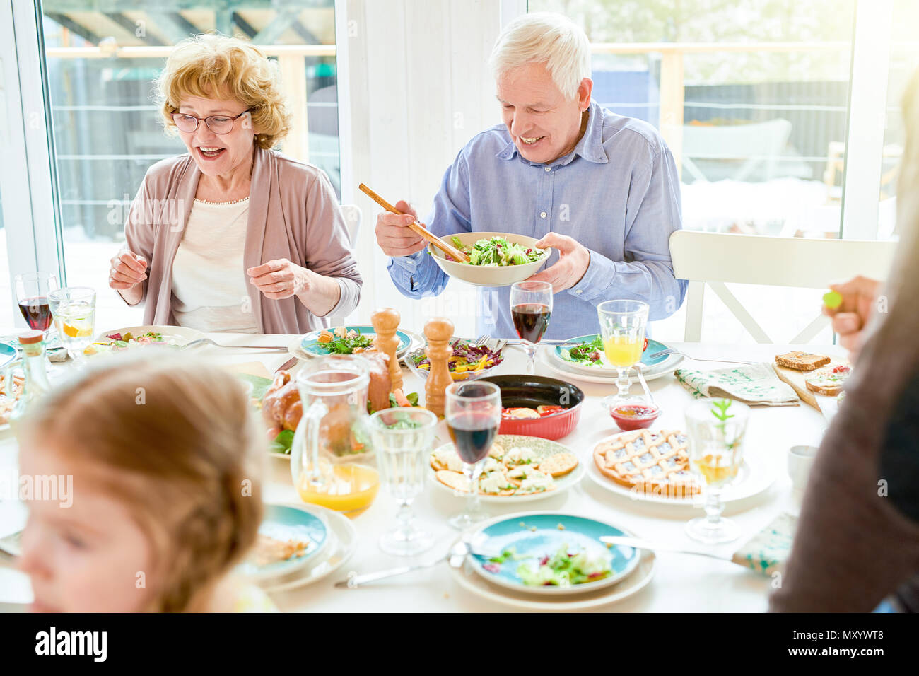 Portrait of happy family enjoying dinner together sitting round festive table with delicious