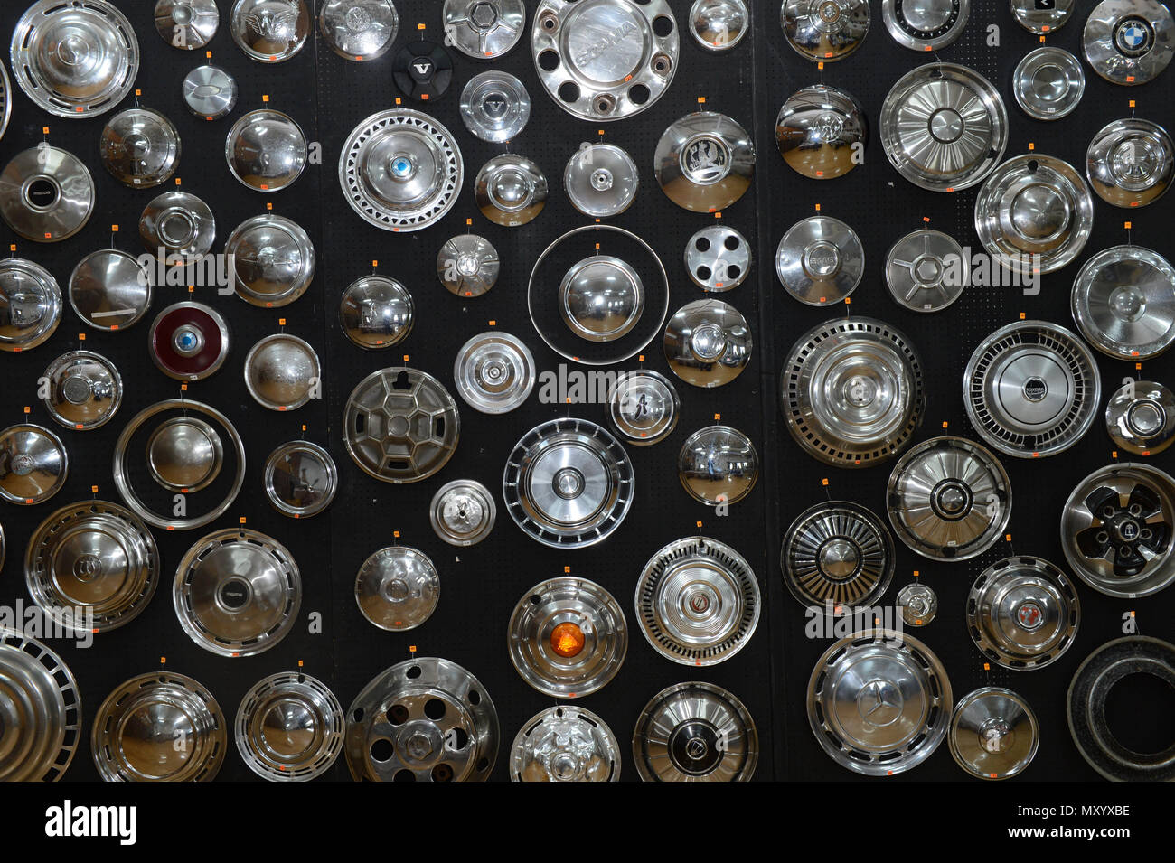 A variety of chrome hub caps in different shapes and sizes from different cars on a black background at the Shetland Classic Car show 2018 Stock Photo
