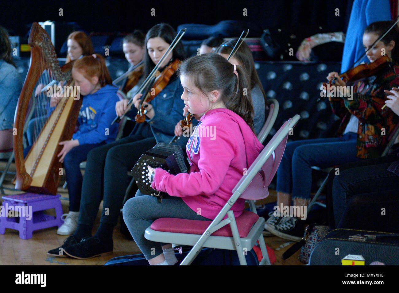 Young girl playing the concertina at a traditional Irish music event in