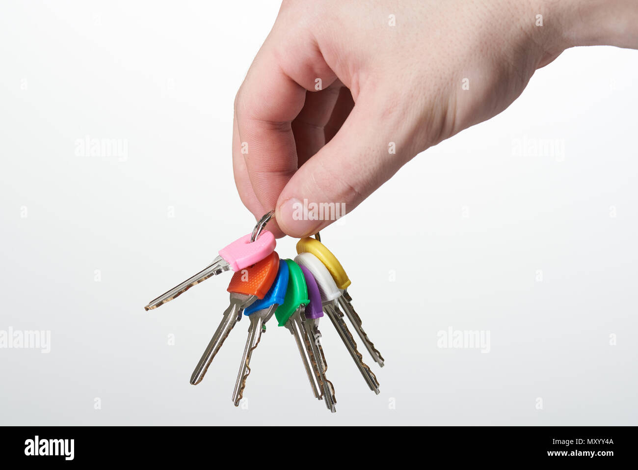 Hand holding set of colorful lock keys isolated on white background ...