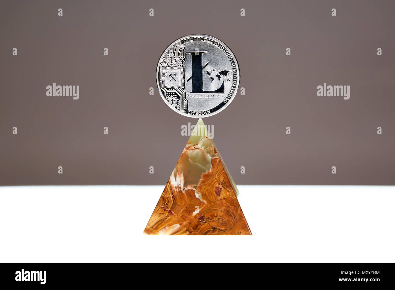 LiteCoin sitting a top a translucent Onyx Stone. Stone symbolizes, personal power, change, facing fears.  All things people who trade crypro face Stock Photo