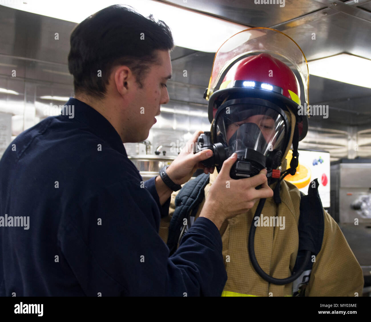 161217-N-KB426-030 WATERS OFF THE COAST OF JAPAN (Dec. 17, 2016) Petty Officer 3rd Class Jeremy S. Snyder, left, teaches Seaman Ronald Howard, right, how to properly don a self-contained breathing apparatus (SCBA) during a “general quarters” drill aboard the Arleigh Burke-class guided-missile destroyer USS John S. McCain (DDG 56). McCain is on patrol in waters off the coast of Japan in supporting security and stability in the Indo-Asia-Pacific region. (U.S. Navy photo by Petty Officer 3rd Class James Vazquez/Released) Stock Photo