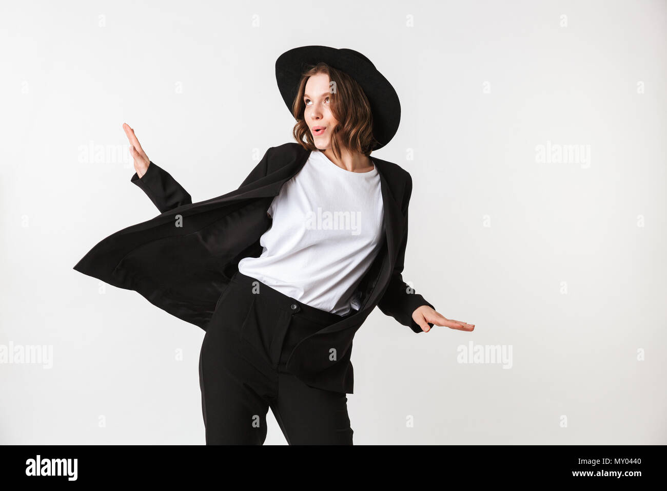 Portrait of a joyful young woman dressed in black jacket and sunglasses ...