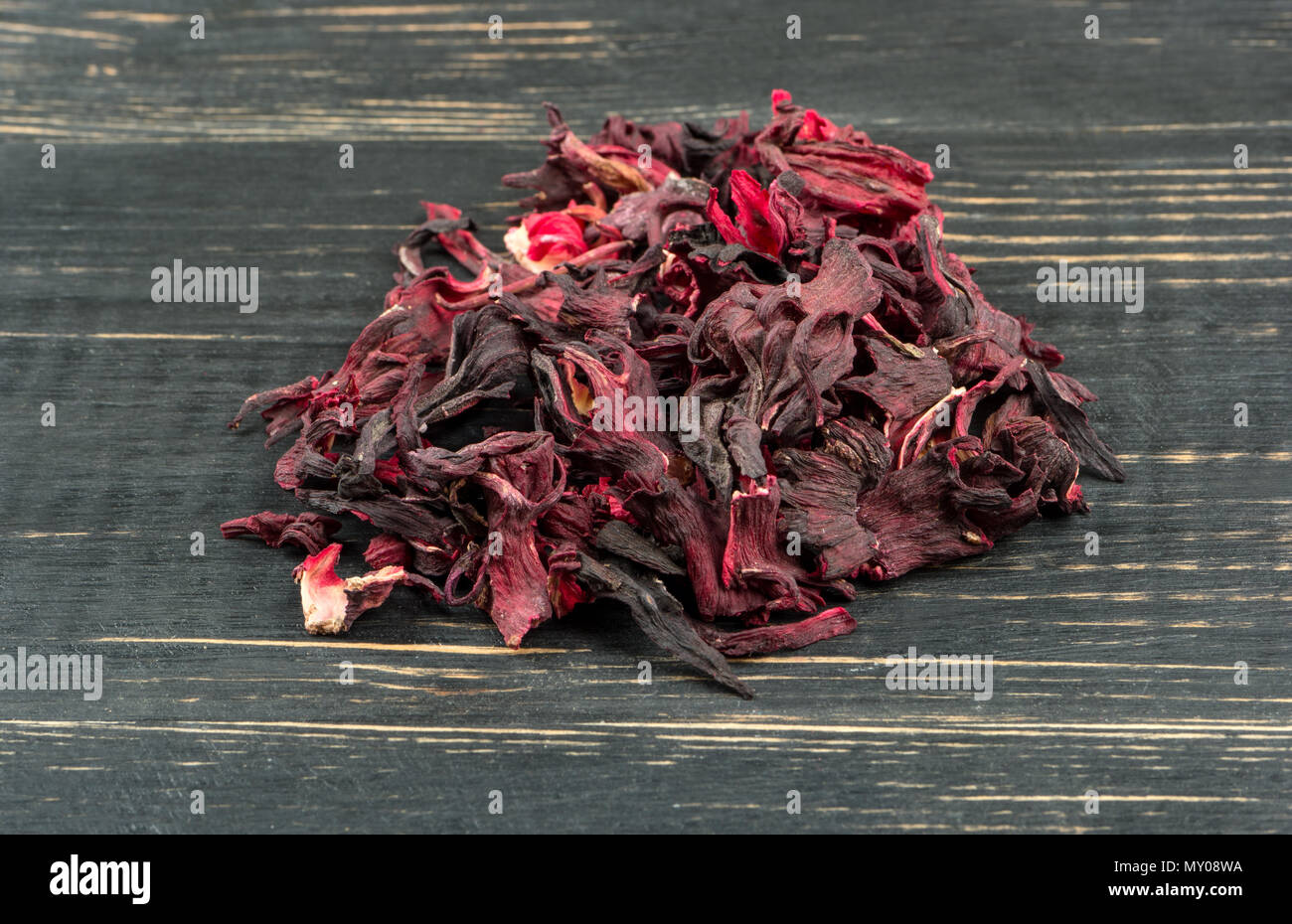 Heap of dry tea hibiscus on a dark table closeup Stock Photo
