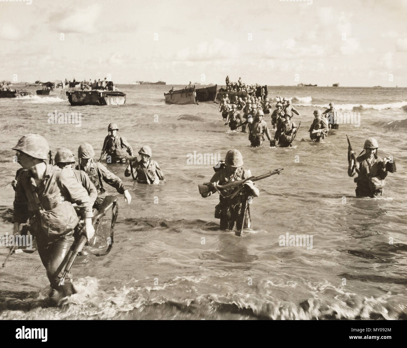 Marines wade ashore from a landing barge on island of Tinian. Taken after 9 days of fighting. Stock Photo