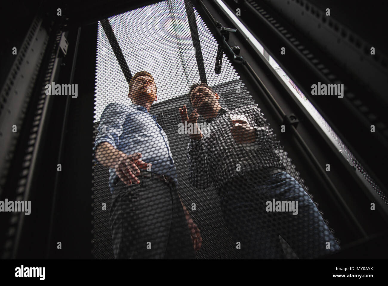 Pleased two colleagues examining server closet Stock Photo