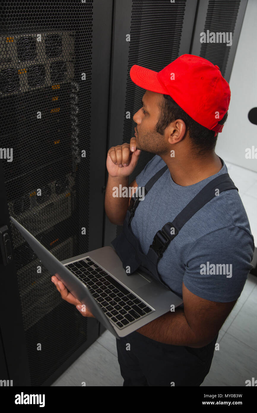 Thoughtful IT engineer keeping servers Stock Photo