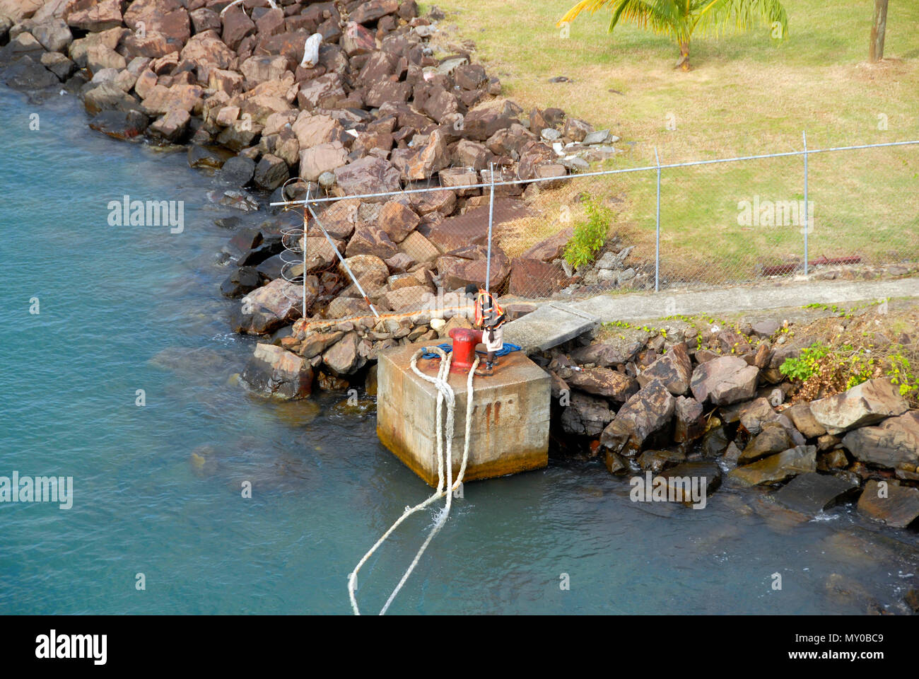 Workman releasing mooring ropes of cruise liner, St Lucia, Caribbean Stock Photo