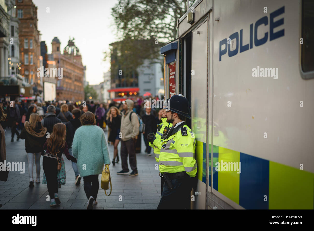 London, UK - October 2017. Policemen patrolling the crowded streets around Leicester Square, in central London. Landscape format. Stock Photo