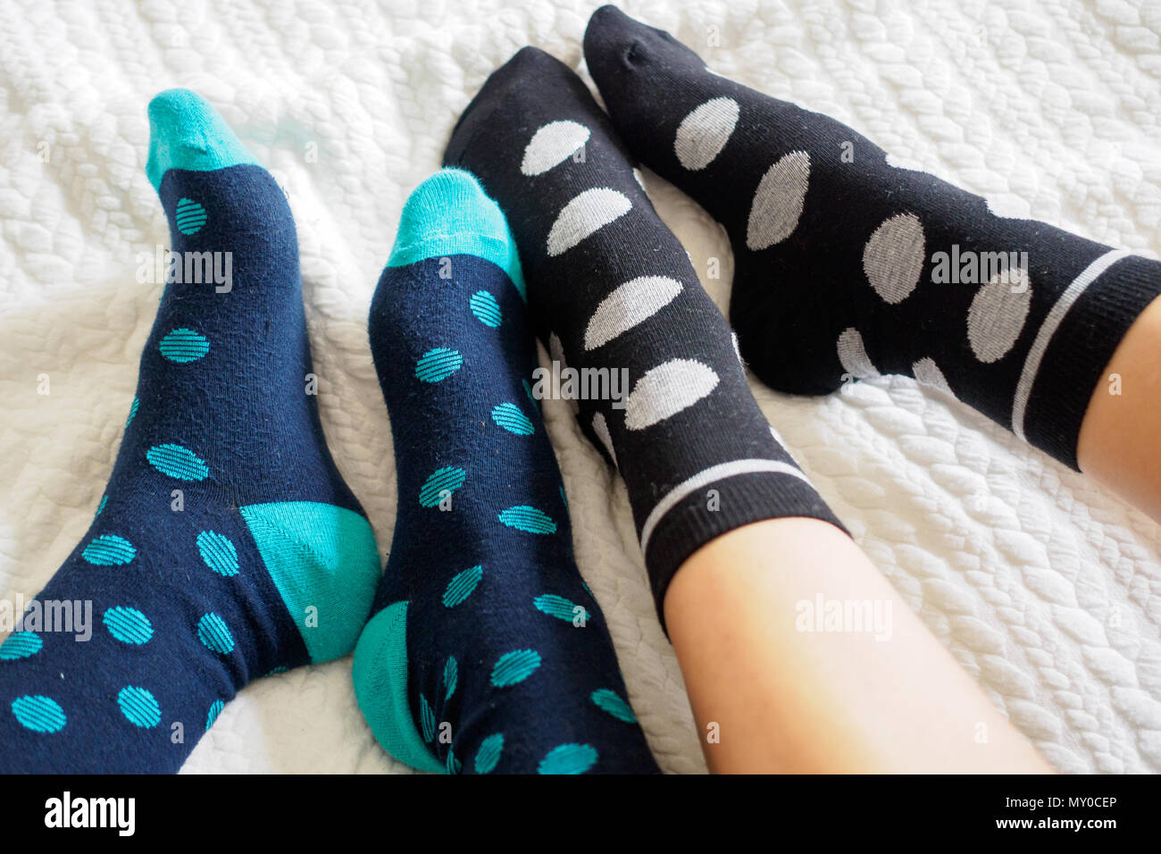 London, UK - November 2017. Young couple posing for a selfie feet wearing blue and white polka dotted socks. Landscape format. Stock Photo