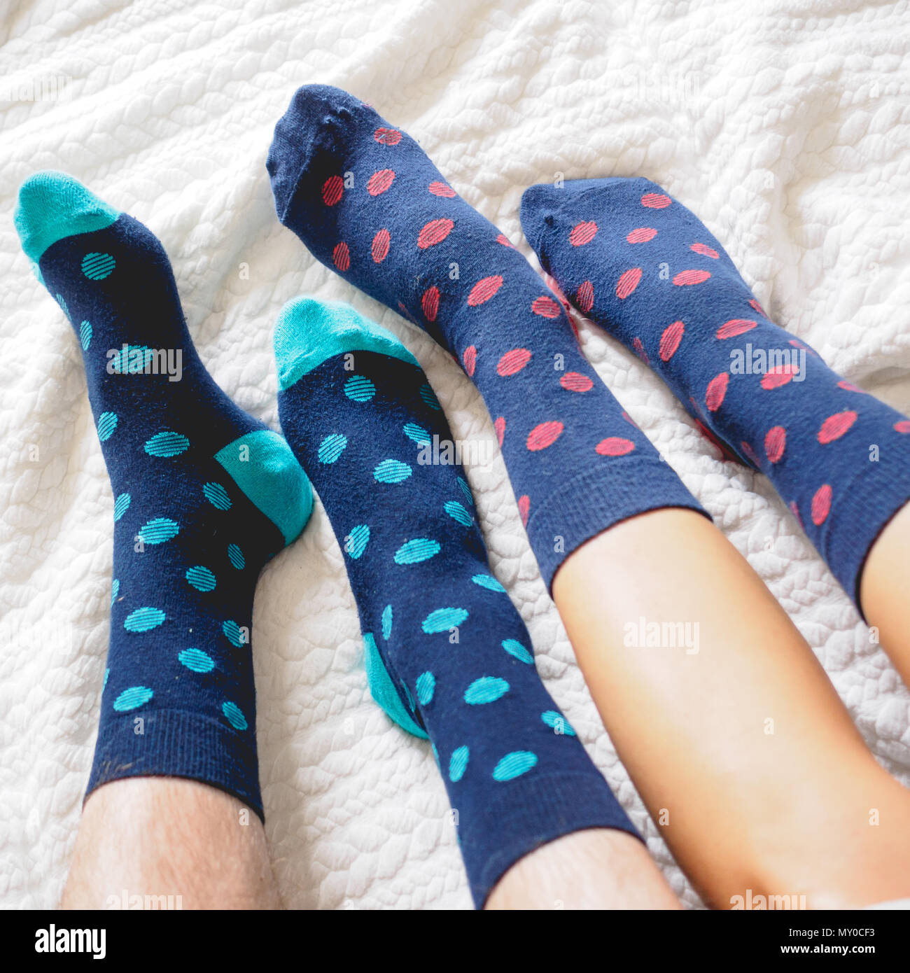 London, UK - November 2017. Young couple posing for a selfie feet wearing blue and white polka dotted socks. Square format. Stock Photo
