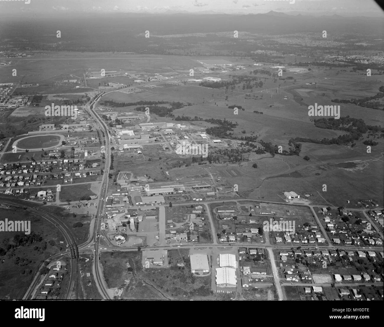 Rocklea from the air, Brisbane, 1967. The industrial suburb of Rocklea in southern Brisbane. ON the left is Rocklea Showgrounds. The road snaking into the distance is Ipswich Road, before it became the Ipswich Motorway. Stock Photo
