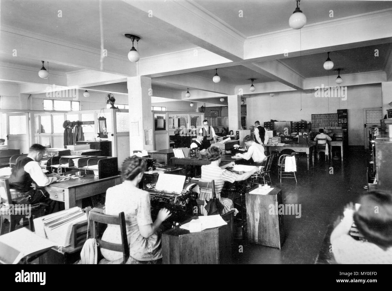 Staff members in the Public Curator's Office, Brisbane, December 1946. The Public Trustee of Queensland was established in 1915 and known as the Public Curator of Queensland until 1978. Units 1 and 2 of the Former Queensland Government Offices (Anzac Square Building) were occupied by the Public Curator in June 1933. Stock Photo