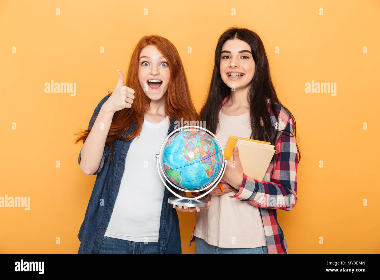 Portrait of two happy young school teenage girls holding copybooks and ...