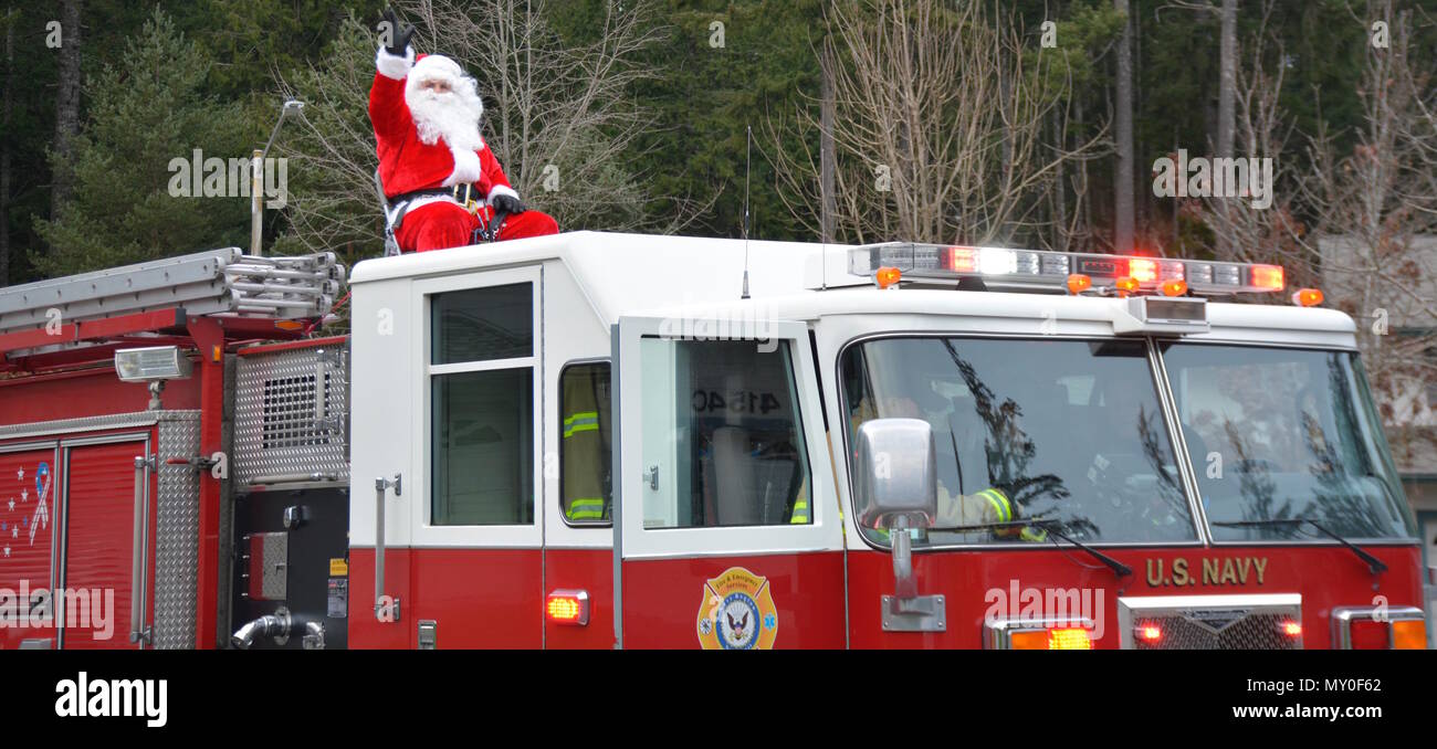 161218-N-UQ990-026 SILVERDALE, Wash. (Dec. 18, 2016) – Santa Claus gets a courtesy ride to Naval Base Kitsap (NBK) – Bangor family housing on a Navy Region Northwest (NRNW) Fire and Emergency Services truck. Santa and his helpers delivered candy to NBK residents at Bangor and Jackson Park. (U.S. Navy photo by Petty Officer 2nd Class Cierra Staples/Released) Stock Photo