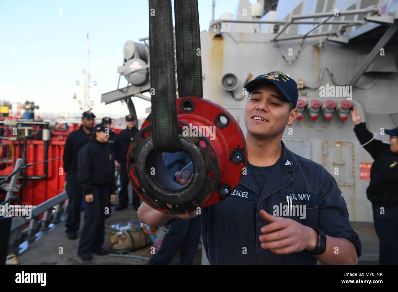 161219-N-JI086-022 - VALENCIA, Spain (Dec. 20, 2016) Petty Officer 3rd Class Enrique Gonzalez, from San Bernardino, Calif., hoists a fuel line adapter aboard the guided-missile destroyer USS Porter (DDG 78) as the ship prepares to take on fuel pier-side in Valencia, Spain, Dec. 20, 2016. Porter, forward-deployed to Rota, Spain, is conducting naval operations in the U.S. 6th Fleet area of operations in support of U.S. national security interests in Europe. (U.S. Navy photo by Seaman Ford Williams/Released) Stock Photo
