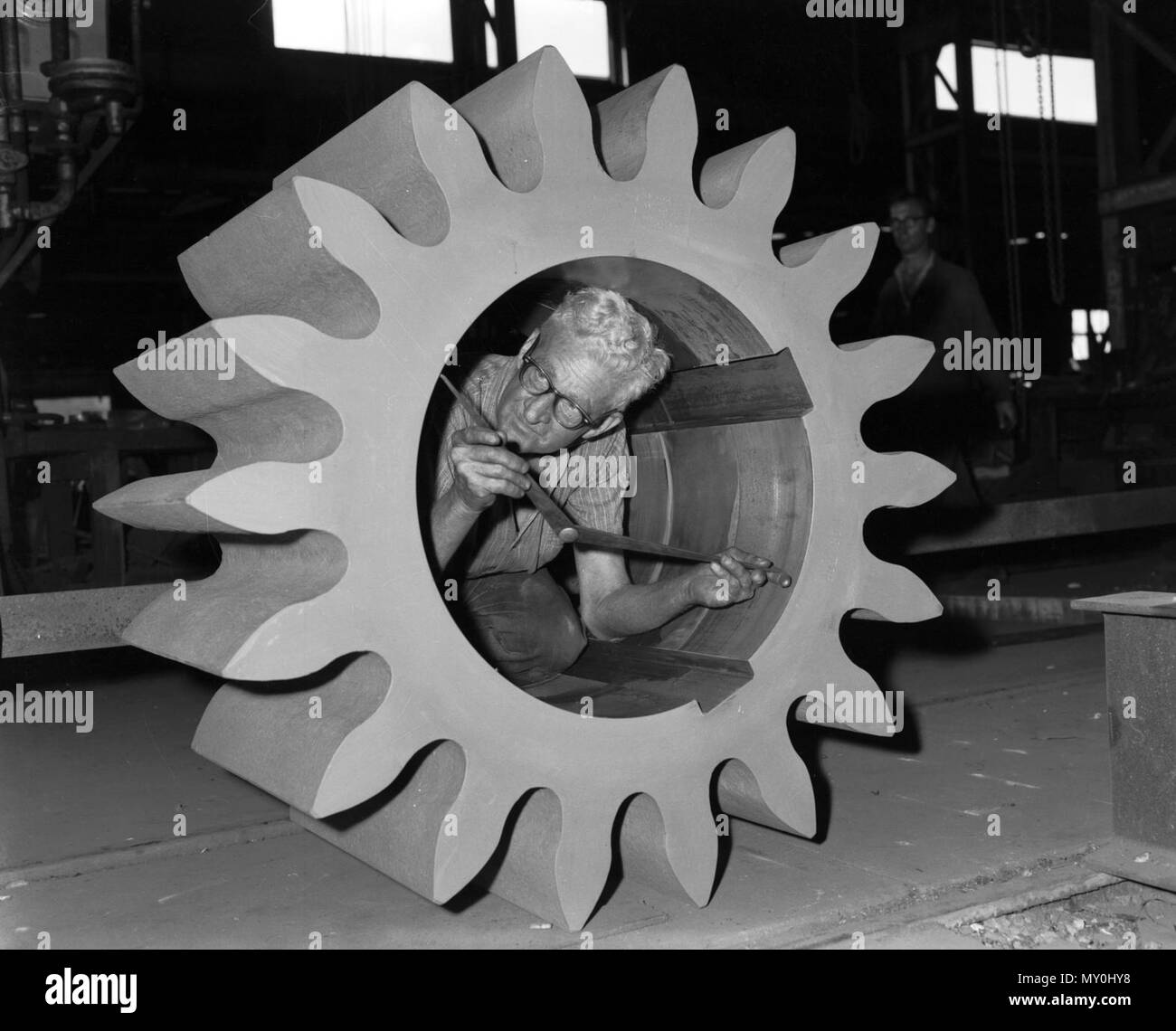 Gear wheel being inspected, Rocklea, 1963. Evans Deakin and Company was an engineering company and shipbuilder based in Brisbane. The Rocklea factory was established in 1926 and fabricated components for the Story Bridge. Stock Photo