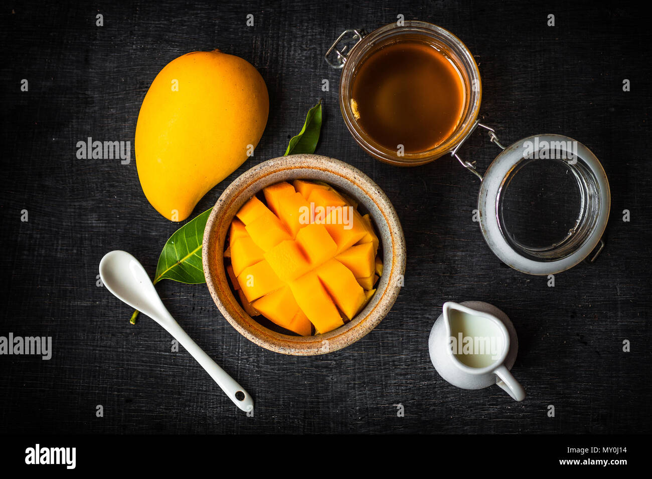 Yellow Mango peel In the cup And honey and coconut milk Stock Photo - Alamy
