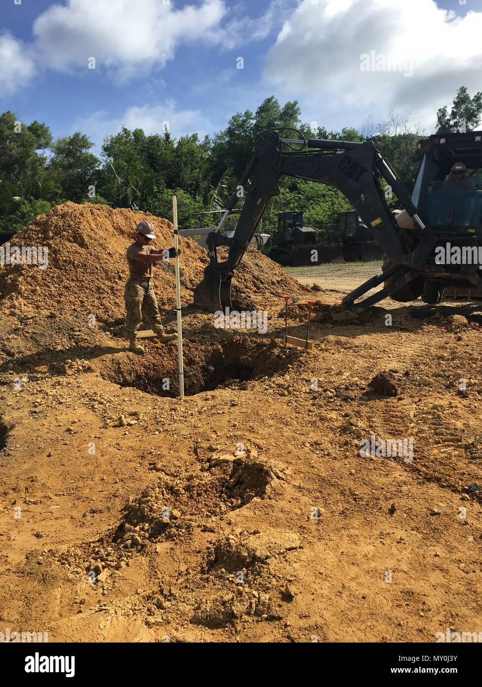 161220-N-VK445-001 CAMP KATUU, PALAU (Dec. 21, 2016) Construction Electrician 3rd Class Anna Sanchez, assigned to Naval Mobile Construction Battalion (NMCB) 5, holds a Philadelphia rod to find the depth of holes for footer placement. NMCB 5 is the forward deployed Western Pacific NMCB ready to support Major Combat Operations and Humanitarian Assistance/ Disaster Relief operations and to provide general engineering and civil support to Navy, Marine Corps and joint operational forces. Homeported out of Port Hueneme, Calif., NMCB 5 has 14 detachment sites deployed throughout the United States and Stock Photo