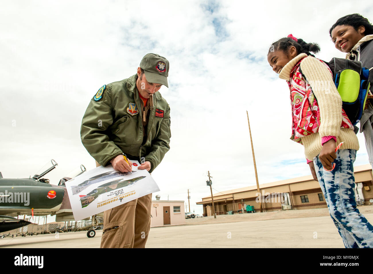 Civilian QF-4E Pilot/Controller Lt. Col. (Ret) Jim “WAM” Harkins, signs a poster for F-4 fans, after exiting his McDonnell Douglas F-4 Phantom II for last time on the final military flight of the storied aircraft at Holloman AFB, N.M., Dec. 21, 2016. The final variant of the Phantom II was the QF-4 unmanned aerial targets flown by the 82nd Aerial Target Squadron Detachment 1 at Holloman AFB. The ceremonial flight was Harkins last in a cockpit for the Air Force; he will now serve as a ground controller for the QF-4's replacement, the QF-16. The F-4 Phantom II entered the U.S. Air Force inventor Stock Photo