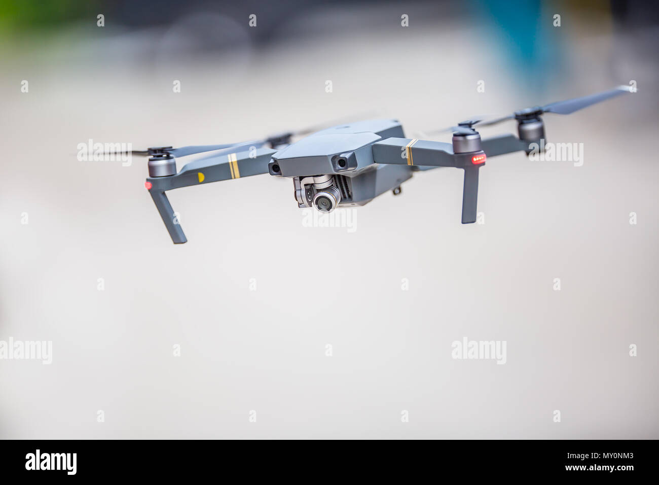 Close-up quadcopter drone with camera flying in park. Stock Photo