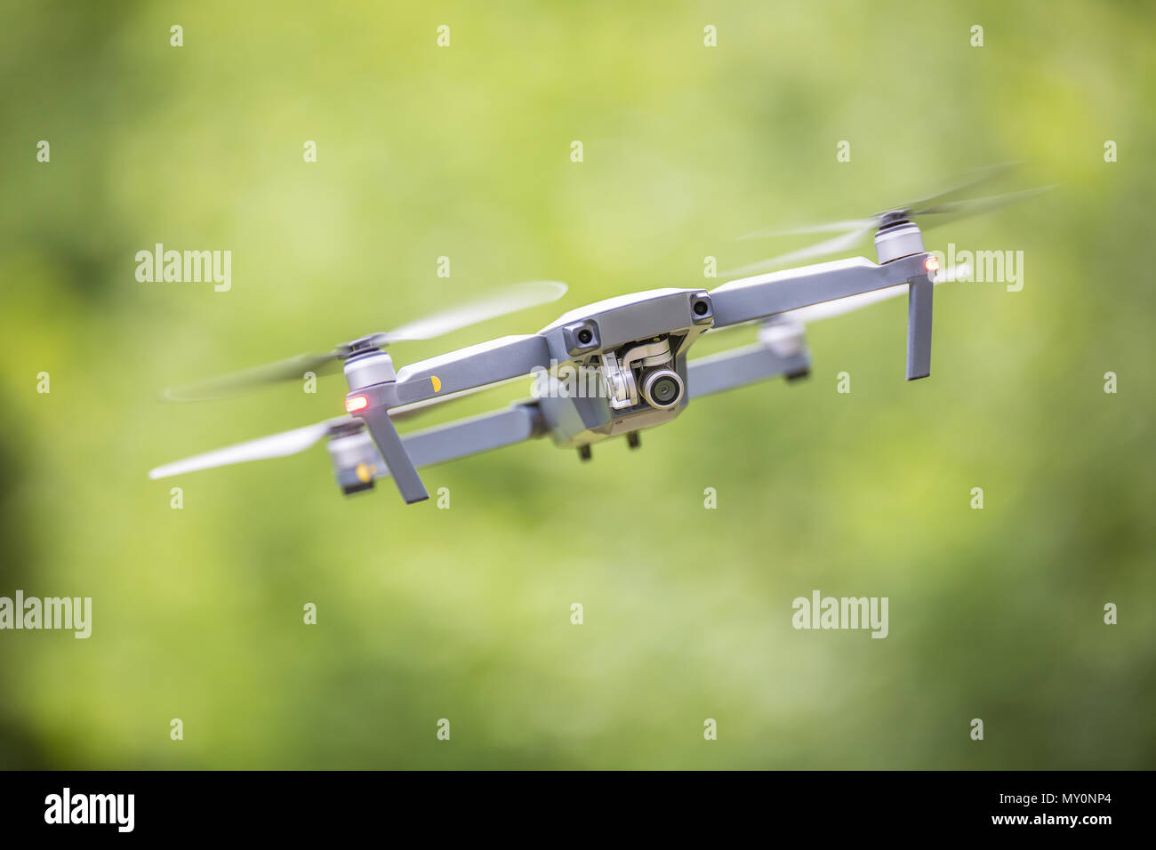 Close-up quadcopter drone with camera flying in park. Stock Photo