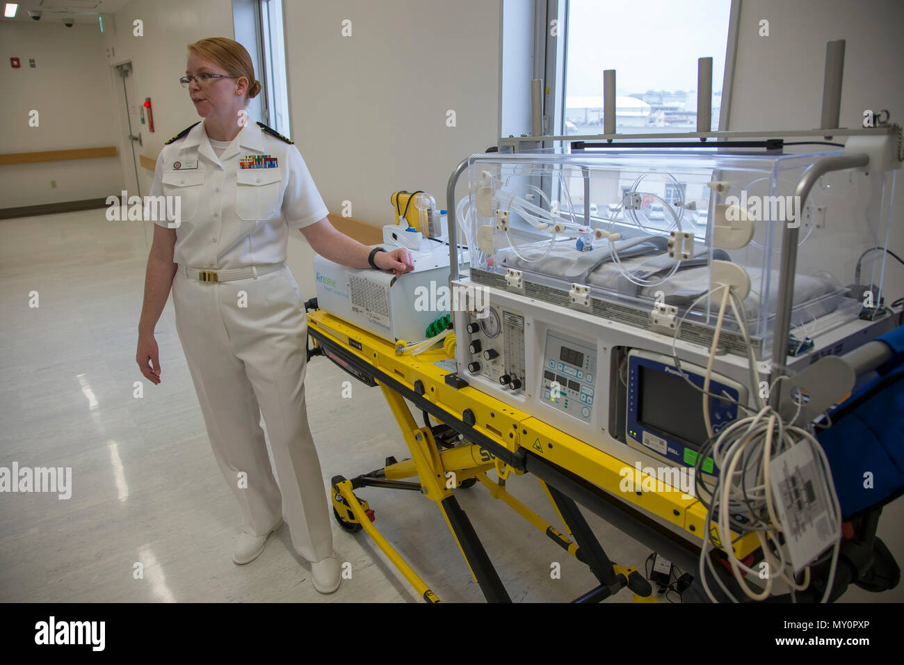U.S. Navy Lt. Cmdr. Eileen Scott, department head of the Mother Infant Care Center at Robert M. Casey Naval Family Branch Clinic Iwakuni, demonstrates the capabilities of a neonatal transporter at Marine Corps Air Station Iwakuni, Japan, May 30, 2018. The demonstration was part of the grand opening of the Robert M. Casey Naval Family Branch Clinic Iwakuni. The staff hosted the grand opening in order to display the facility’s new and improved capabilities. (U.S. Marine Corps photo by Lance Cpl. Seth Rosenberg) Stock Photo