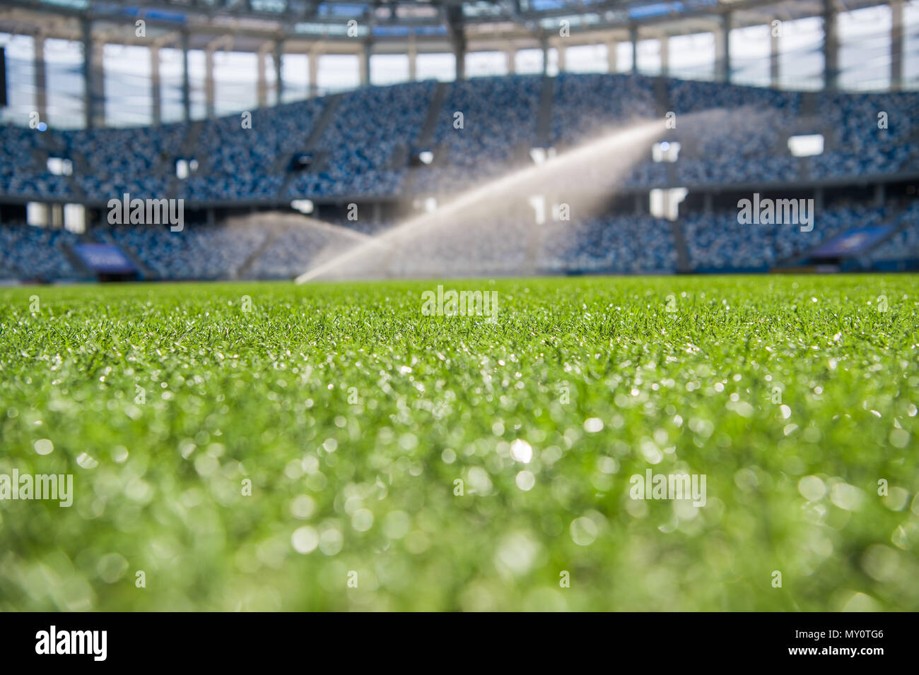 Watering the football field. Close-up macro shot on green grass with white stripe. Stock Photo