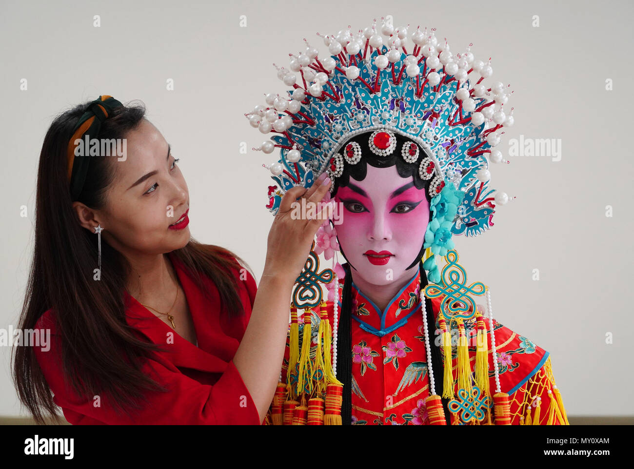 Xi'an, China's Shaanxi Province. 5th June, 2018. Zhang Yuning wears head ornaments guided by Feng Xiaomeng at Northwestern Polytechnical University in Xi'an, capital of northwest China's Shaanxi Province, June 5, 2018. The university started running courses of Peking Opera in September last year to promote traditional opera among students. Peking Opera, listed by UNESCO as an intangible cultural heritage, is the most famous among hundreds of forms of local opera in China. Credit: Shao Rui/Xinhua/Alamy Live News Stock Photo