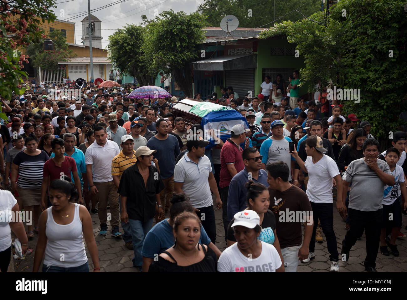 04 June 2018, Nicaragua, Masaya: Mourners carry a coffin with the mortal remains of a 22-year-old. For the most part, Masaya is controlled by government opponents that set up barricades and deny access to the police. Hooded gunmen stormed the city on Sunday night (local time) according to human rights activists. Photo: Carlos Herrera/dpa Stock Photo