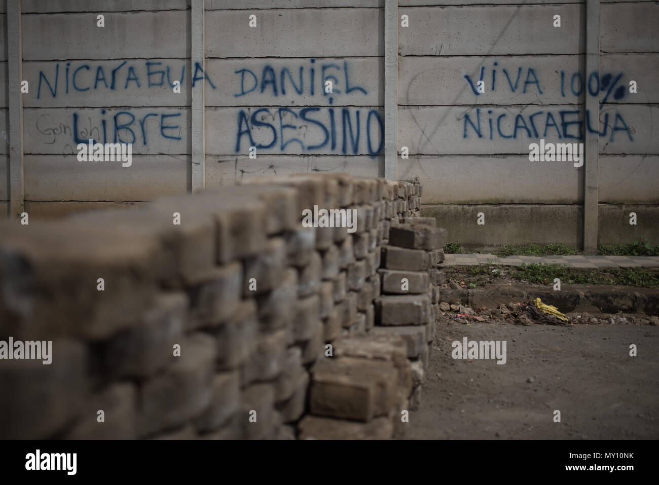 04 June 2018, Nicaragua, Masaya: A wall reads 'Nicaragua Libre. Daniel, Asesino. Viva 100% Nicaragua' (lit. free Nicaragua, Daniel, murderer, live 100% Nicaragua) next to a barricade. For the most part, Masaya is controlled by government opponents that set up barricades and deny access to the police. Hooded gunmen stormed the city on Sunday night (local time) according to human rights activists. Photo: Carlos Herrera/dpa Stock Photo